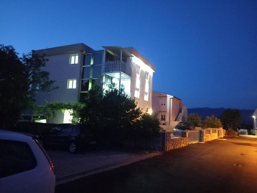 奥米沙利D,apartman的前面有停车位的建筑