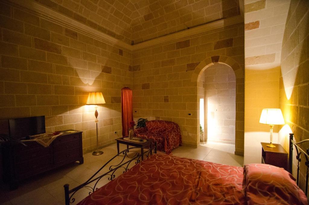 曼杜里亚Corte Schiavoni B&B的一间卧室配有一张床、一张桌子和一盏灯
