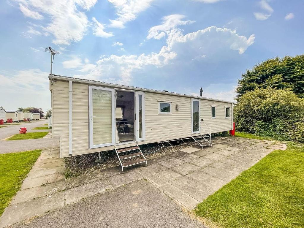 斯凯格内斯Homely 8 Berth Caravan In Southview Holiday Park, Ref 33048tc的白色的小房子,带有庭院和草地