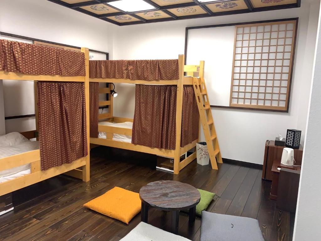 东京Shinjuku Miyabi Residence - Vacation STAY 94836的客房设有双层床、桌子和窗户。