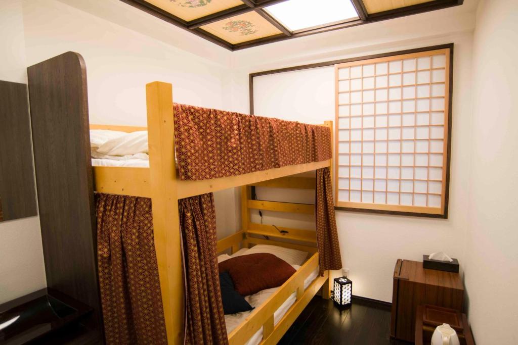 东京Shinjuku Miyabi Residence - Vacation STAY 94701的客房设有两张双层床和一扇窗户。