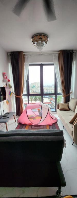 哥打巴鲁Prestige Troika Kota Bharu的一张粉红色的伞躺在房间里的床边