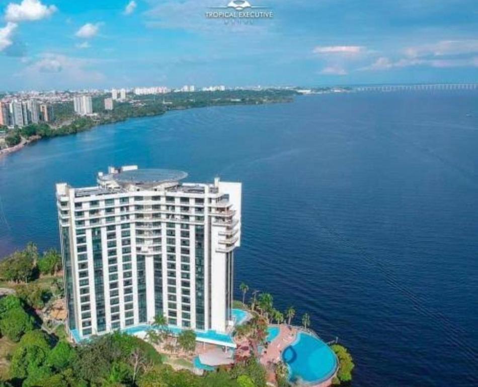 马瑙斯Flat Hotel Tropical Executive Praia Ponta Negra的水边一座大建筑的空中景观