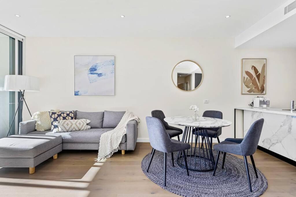 悉尼Macquarie Park Executive 2 Bedroom的客厅配有沙发和桌椅
