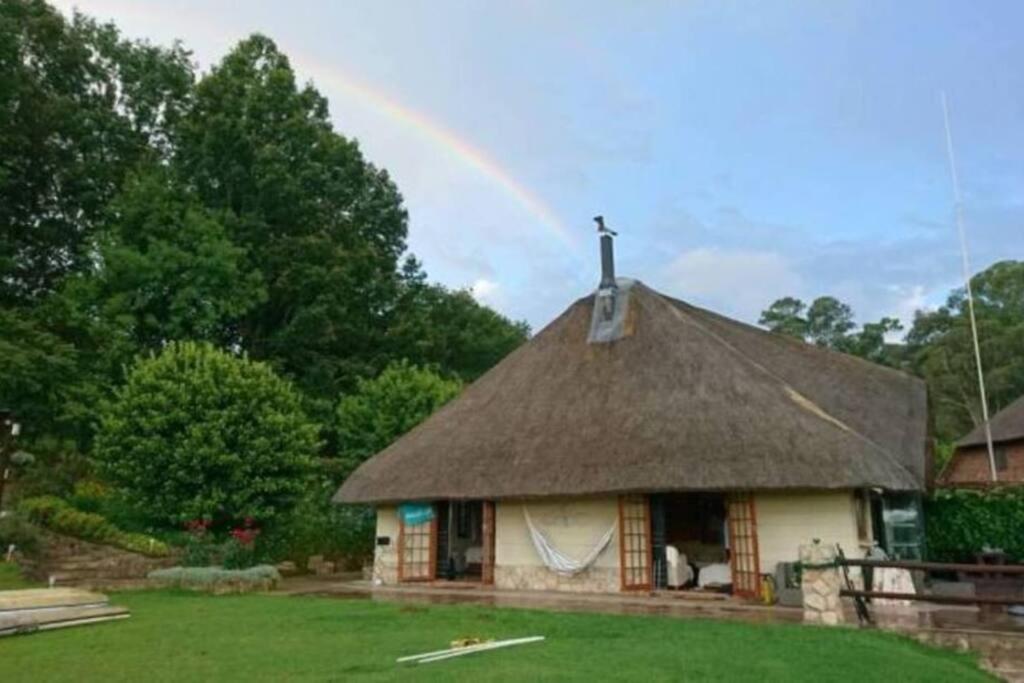 安德伯格The Underberg Cottage的茅草屋顶下方有彩虹的房子