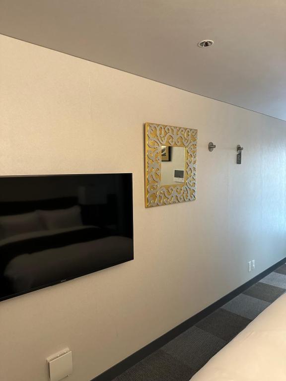 大阪Hotel 草石庵的墙上的壁挂式平面电视