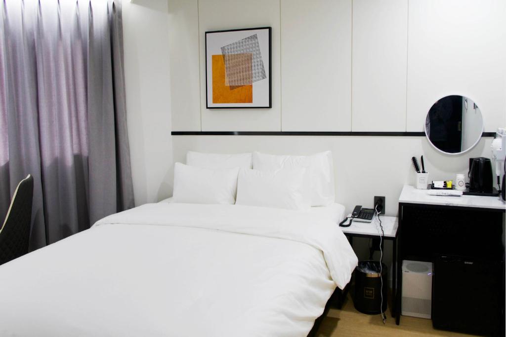 堤川市Number 25 Hotel Jecheon的卧室配有白色的床和书桌