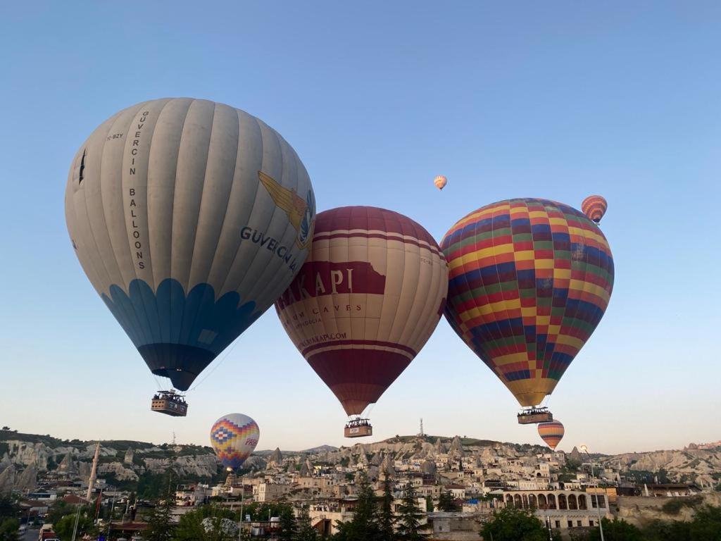 格雷梅Cappadocia Kepez hotel的三个热气球飞越一个城市