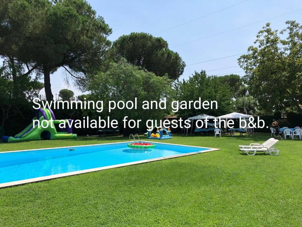 拉斯图塔Vacanze Romane Olgiata的游泳池和花园不对烧烤区的客人开放。