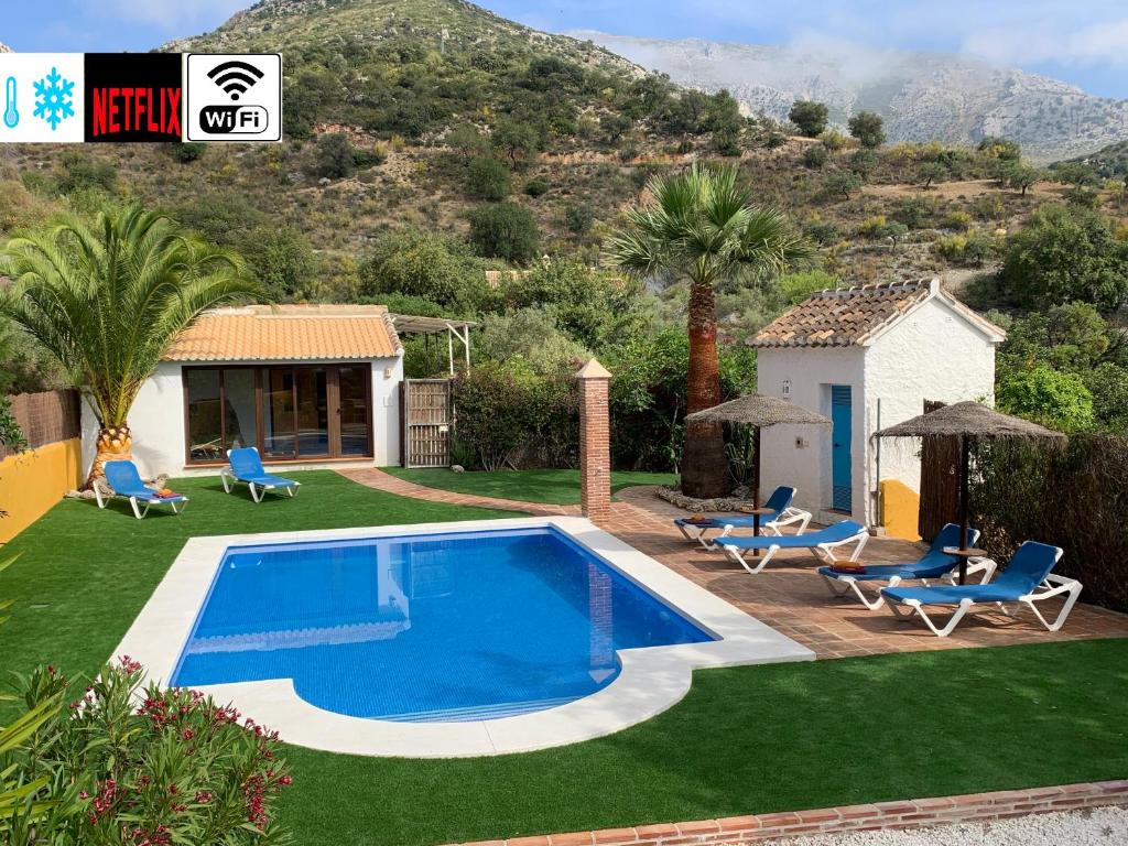 埃尔乔罗Casa Rural La teja (Caminito del Rey)的一个带椅子的庭院和房子的游泳池