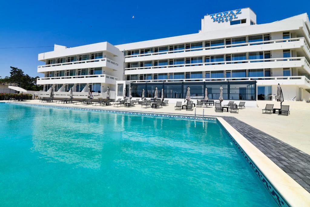 卡普奥罗拉HOTEL TOPAZ 4* CAP AURORA的大楼前设有游泳池的酒店
