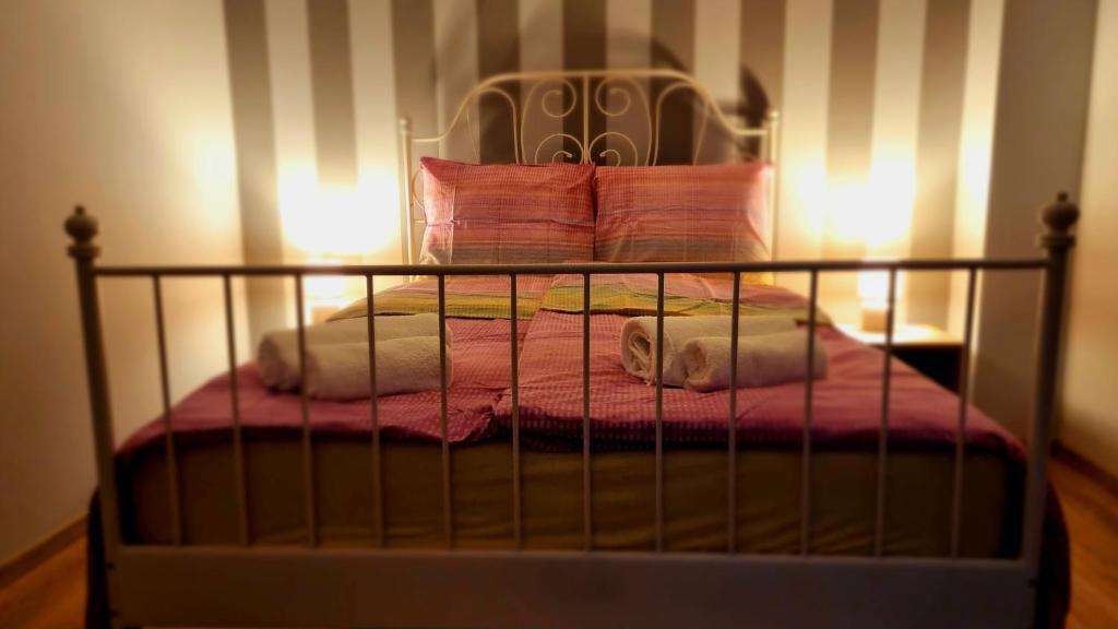 维德米内Apartament G66的一张带粉色毯子和枕头的床