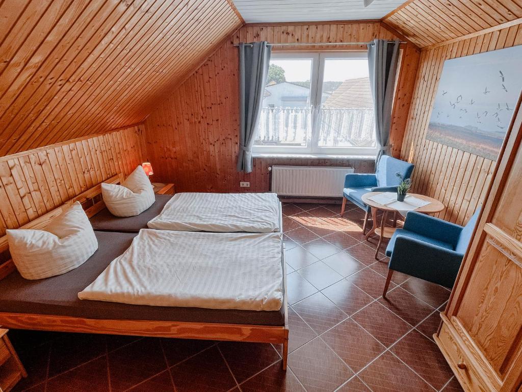 DargenFerienwohnung 2的一间卧室配有一张床、两把椅子和一个窗户