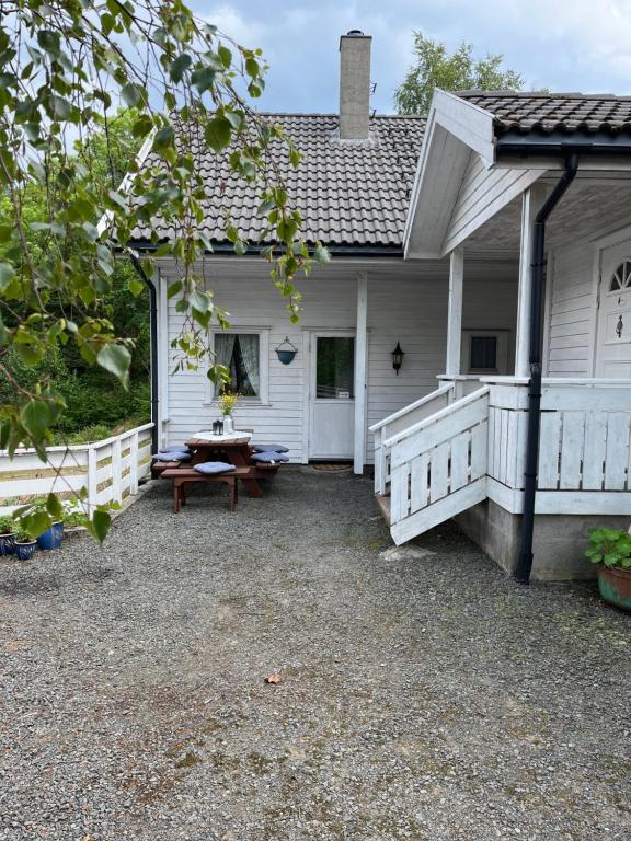 HidraBjørkely gård的白色房子,门廊上设有野餐桌