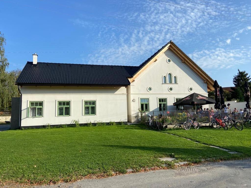SkutečPension Sodomkův statek Czap的一间白色的房子,有黑色的屋顶和院子