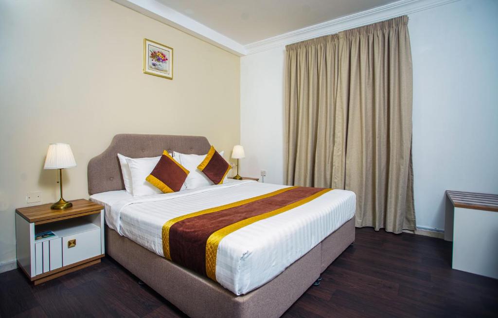 多哈别墅套房酒店的一间设有大床和窗户的酒店客房