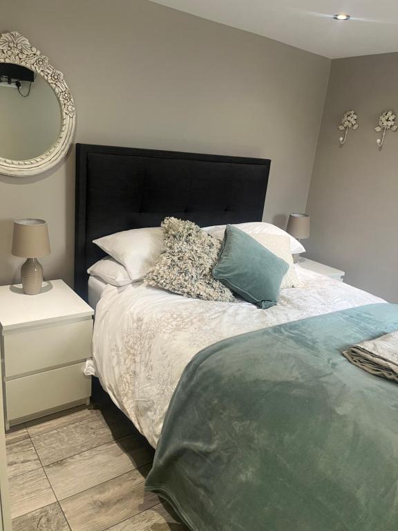 克努斯福德Brand new apartment in Knutsford的一间卧室配有一张带黑色床头板和镜子的床