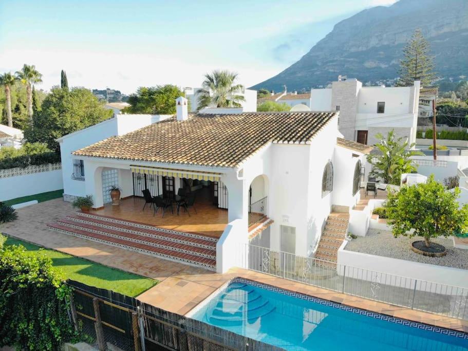 德尼亚Casa Anemone的一座白色的房子,前面设有一个游泳池