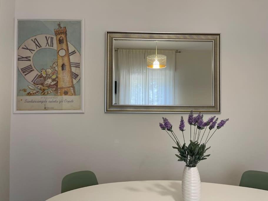 圣阿尔坎杰洛-迪罗马涅Casetta Mia - Holiday Family House的一张带紫色花卉和镜子的花瓶的桌子