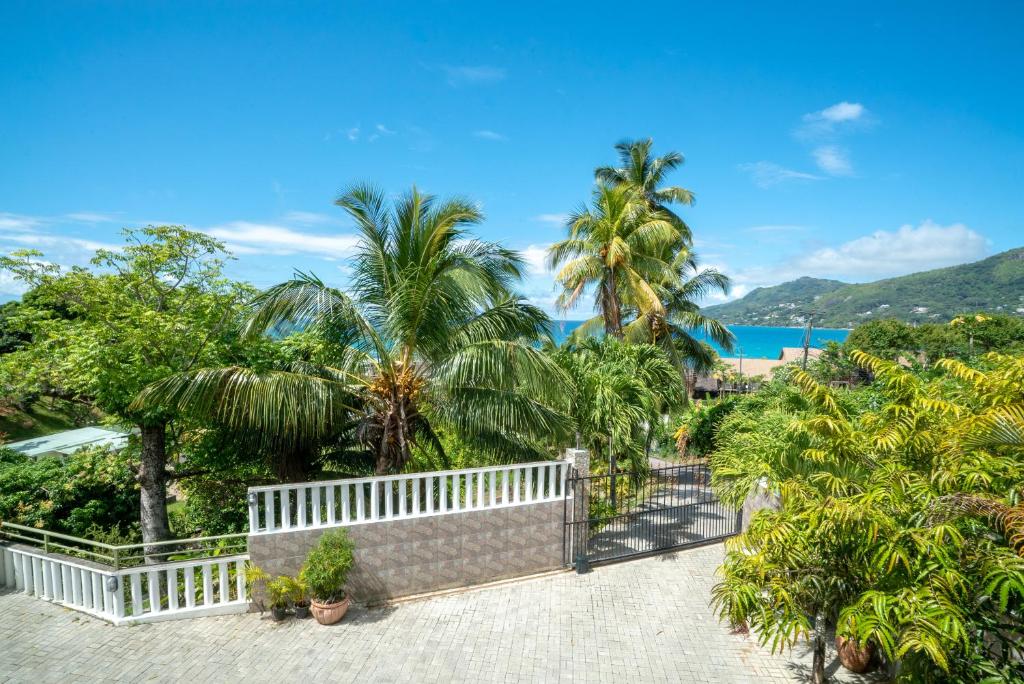 博瓦隆La Belle Residence Self Catering Accommodation的享有棕榈树度假村和大海的景致。