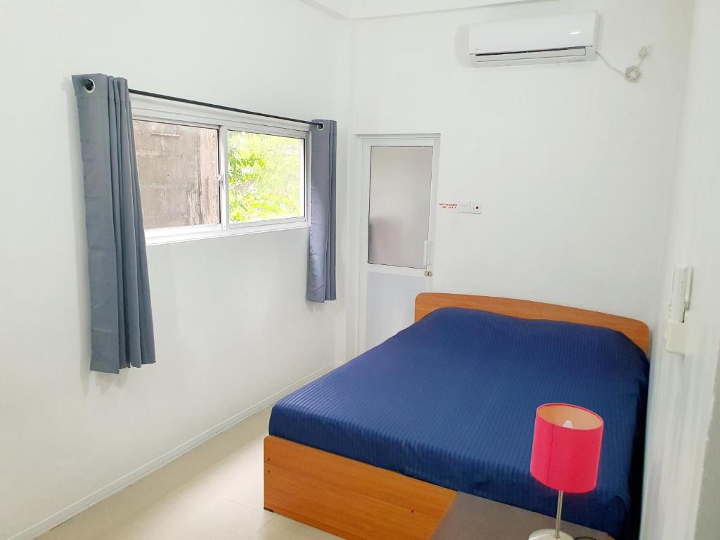 努格古达宾至如归度假屋的一间卧室设有蓝色的床和窗户。