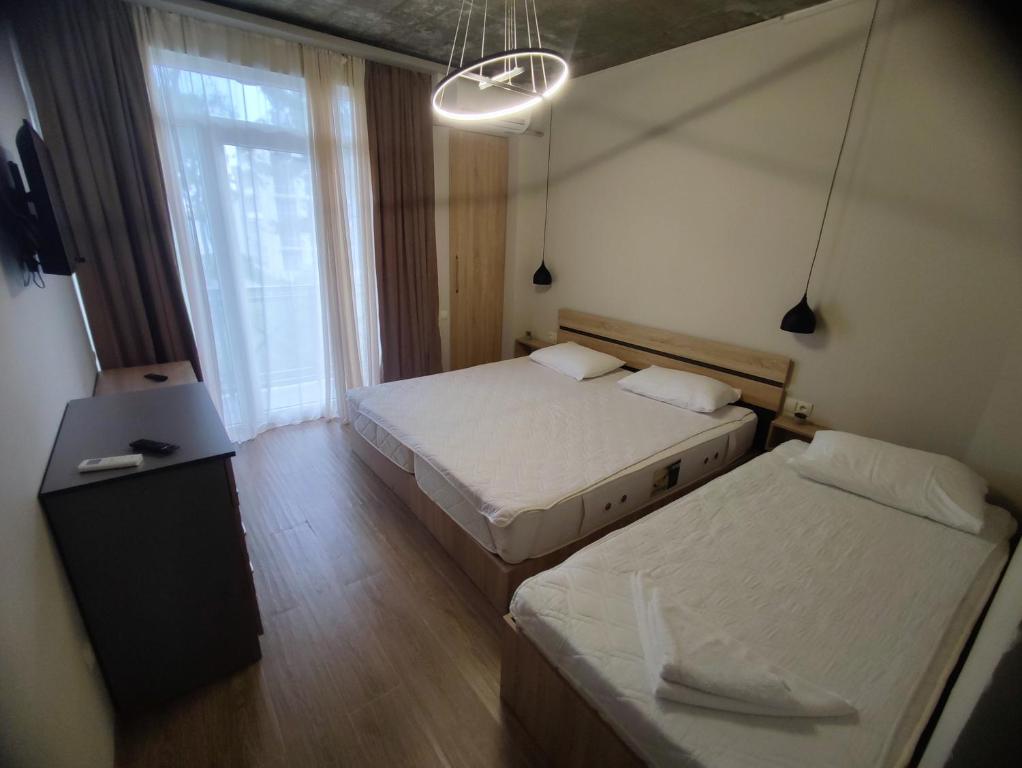 谢赫维蒂利Home Shekvetili的一间卧室设有两张床、一张桌子和一个窗口