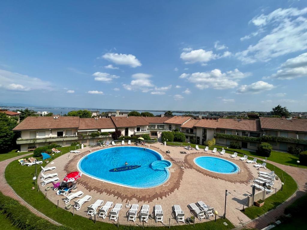 代森扎诺-德尔加达克里斯塔尔拉格公寓式酒店的享有2个带躺椅的游泳池的上方景致