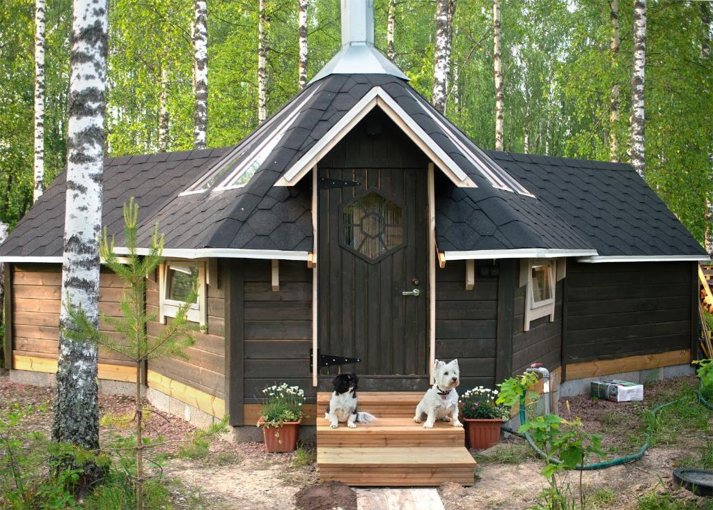 埃斯波Troll House Eco-Cottage, Nuuksio for Nature lovers, Petfriendly的狗屋门廊上的两只狗