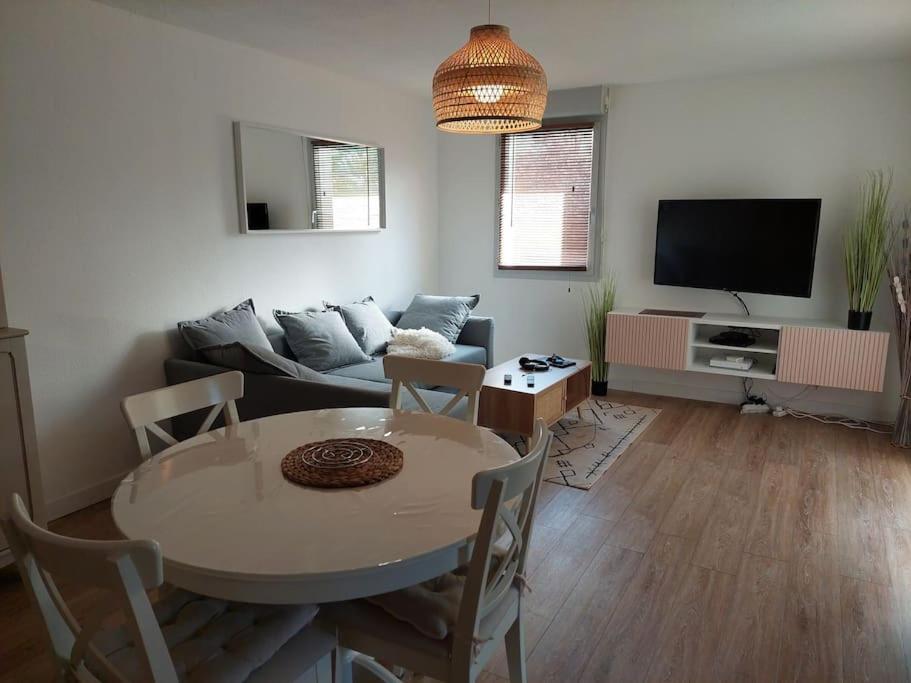 图尔Appartement 65 m² avec piscine.的客厅配有桌子和沙发