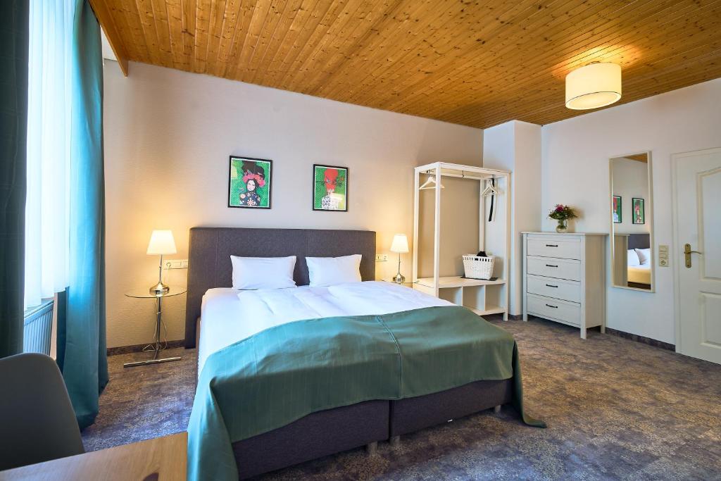 巴登-巴登赫希兰德卡斯托酒店的一间卧室设有一张带木制天花板的大床