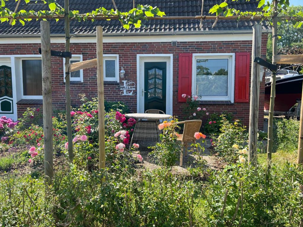 PogumLa Petite Gloire的花园,位于一座红色门的房子前