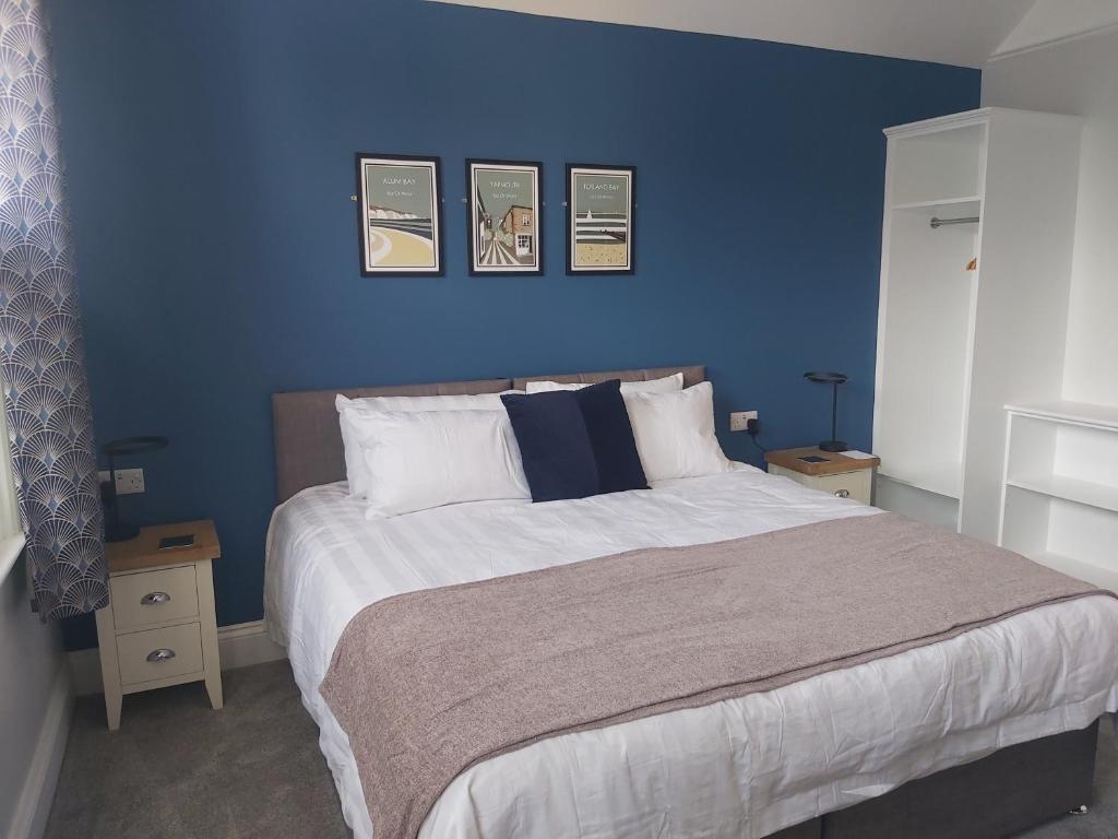 托特兰Bay House的蓝色卧室设有一张带蓝色墙壁的大床