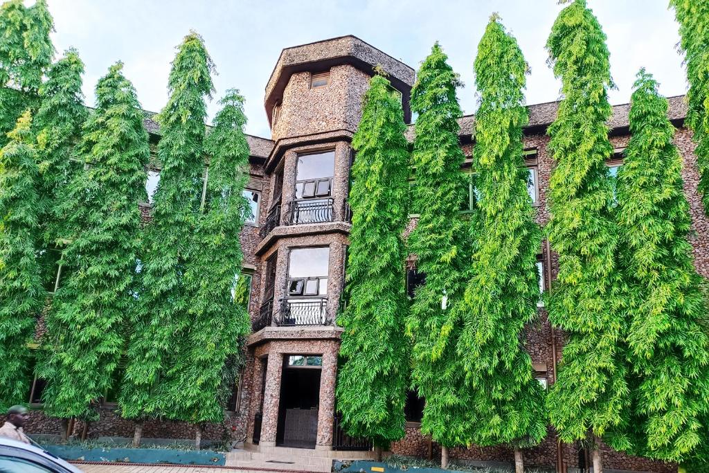 恩德培DISCOVERY COURTS HOTEL的一座绿树成荫的老砖砌建筑