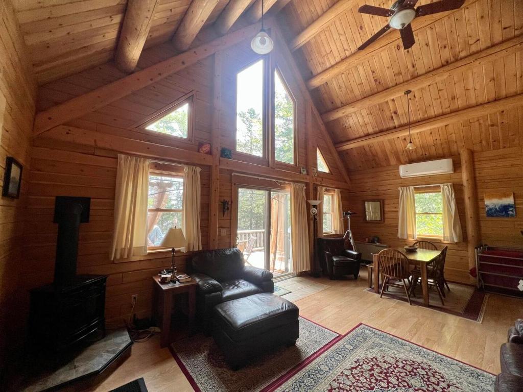 Beddington Lake Log Cabin的客厅设有木墙和窗户。