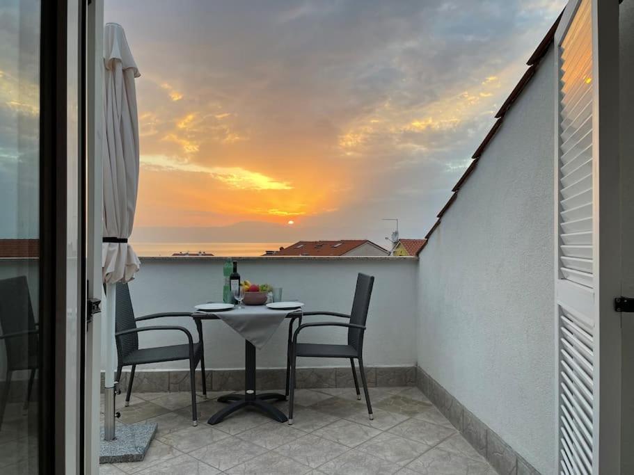 奈维斯Casa Estancia Studio Apartment的阳台的桌椅享有日落美景