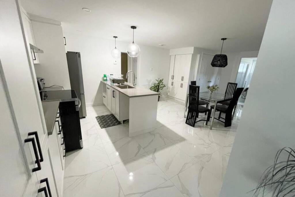 隆格伊Stylish and luxurious apartment basement unit的白色的厨房设有水槽和台面