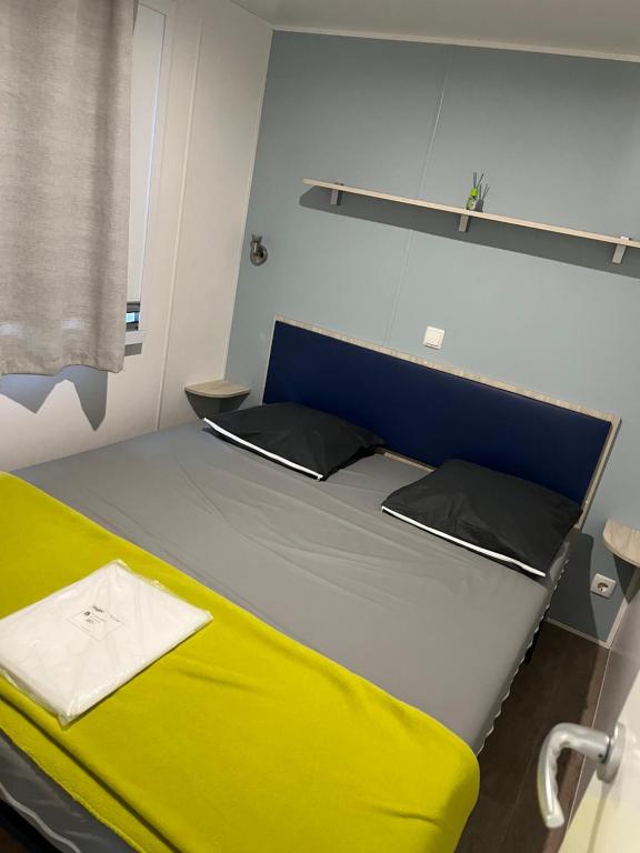 勒格罗-迪鲁瓦Mobile home camping的一张大床,位于一个黄色床垫的房间