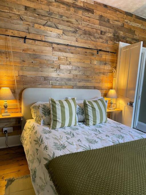 克里克豪厄尔Cosy 2 bed flat in Crickhowell的一间卧室配有一张木墙床