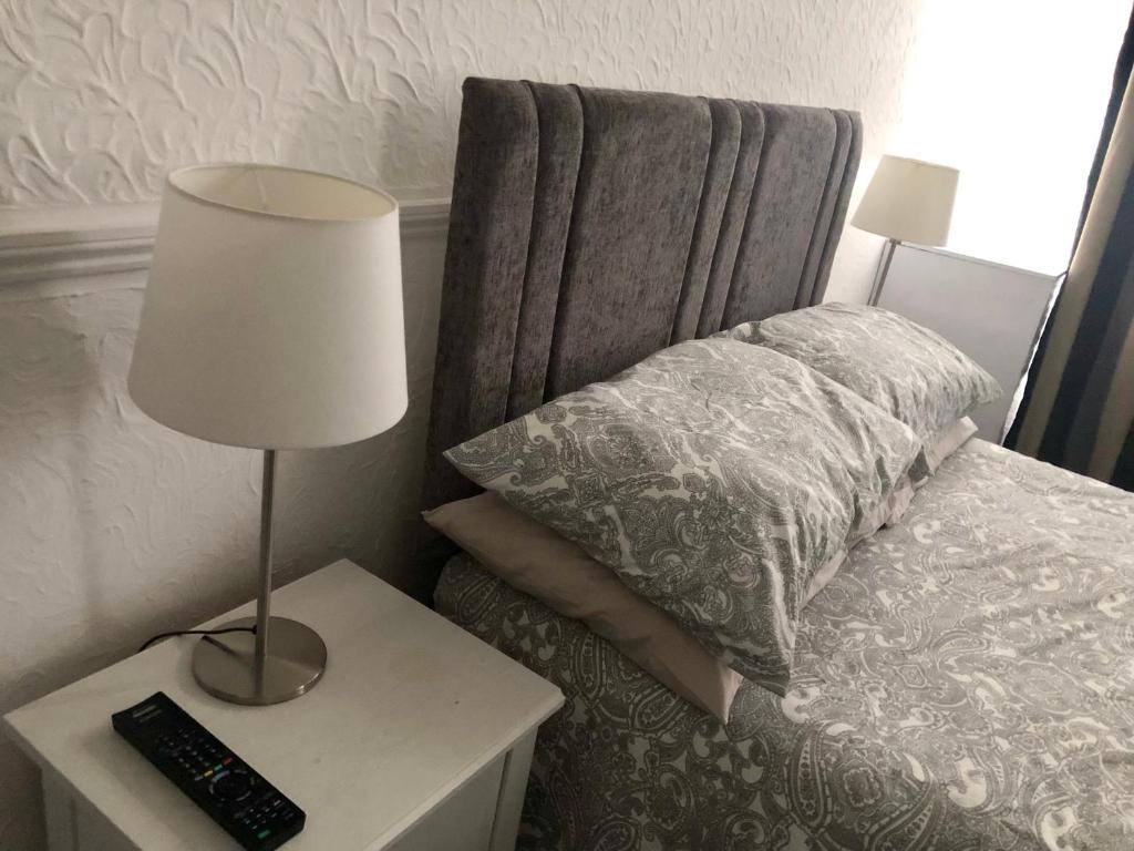 罗奇福德AC Lounge 125的一间卧室配有一张带台灯和枕头的床
