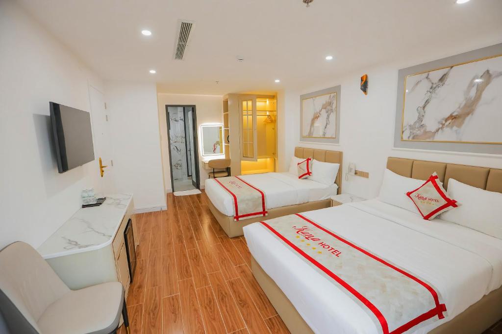 芽庄Kana Hotel Nha Trang的酒店客房设有两张床和电视。