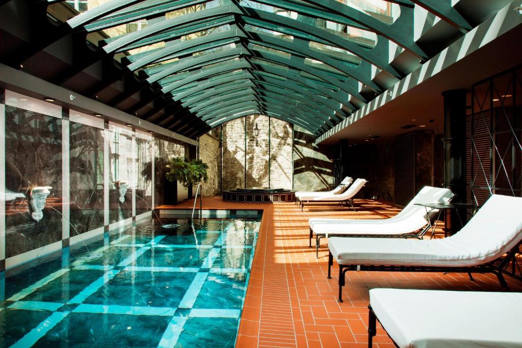 塔林特勒格拉夫傲途格精选酒店的一个带椅子和天花板的游泳池