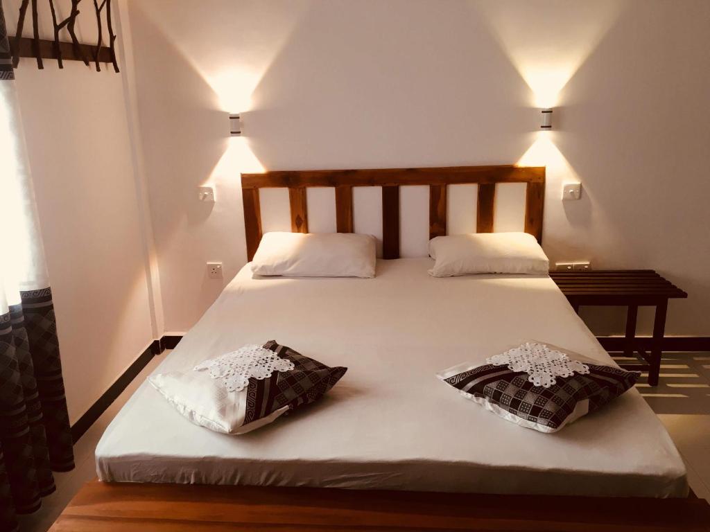 达瓦拉维Wild Eagle Safari Resort的一张带两个枕头的大白色床