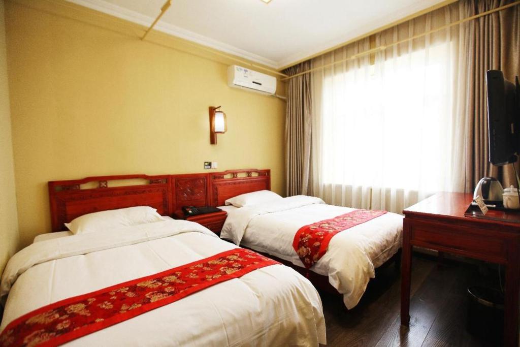 北京北京合德缘四合院酒店的配有窗户的酒店客房内的两张床