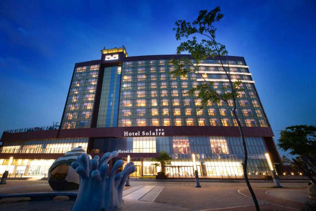 保宁市Hotel solaire的一座酒店大楼,上面有一个钟