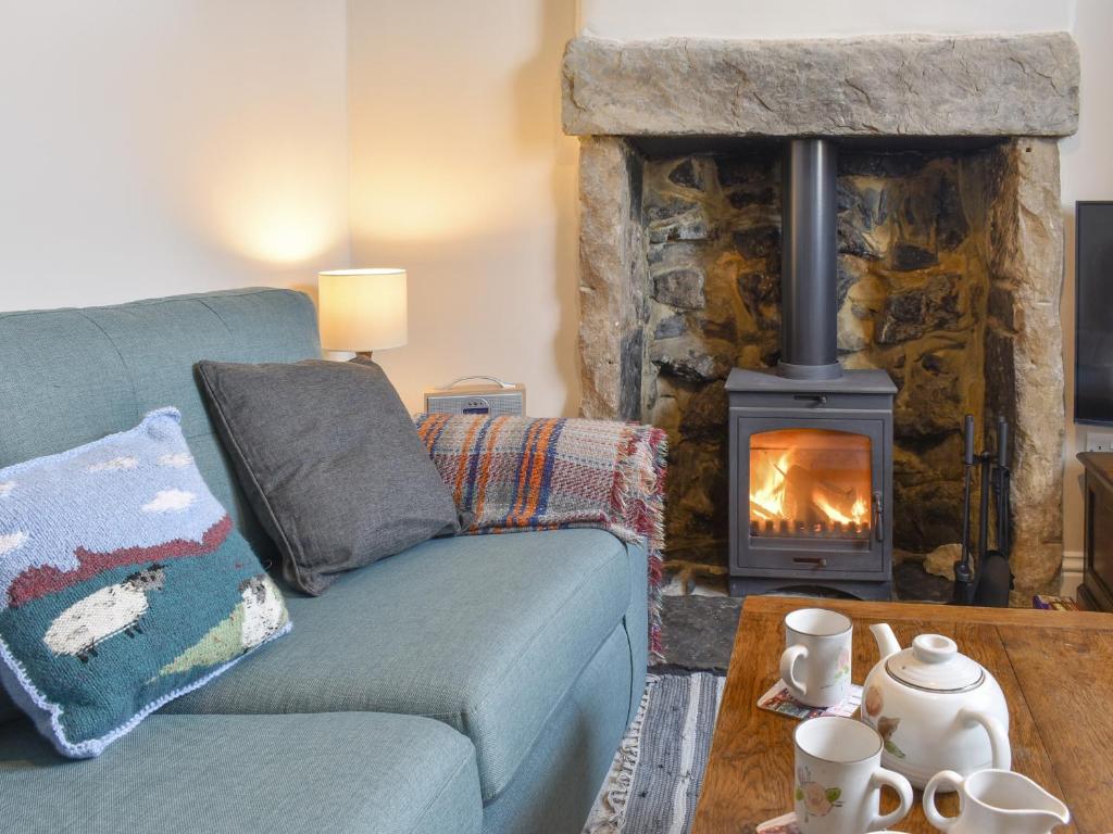 Great LongstoneCorner Cottage的客厅设有蓝色的沙发和壁炉