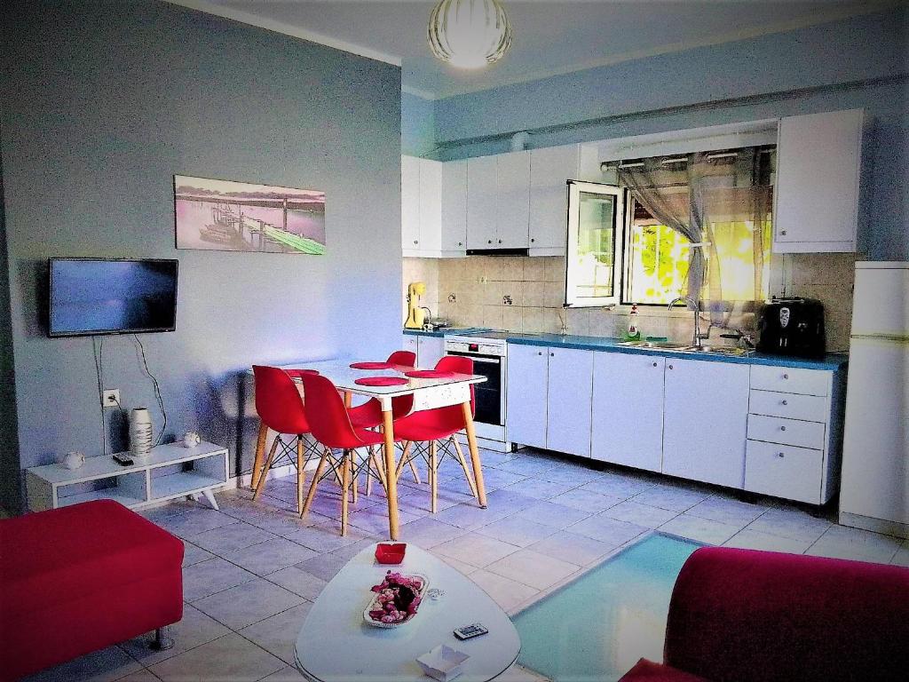 斯基亚索斯镇Rafaela’s House的一间厨房,里面配有桌子和红色椅子
