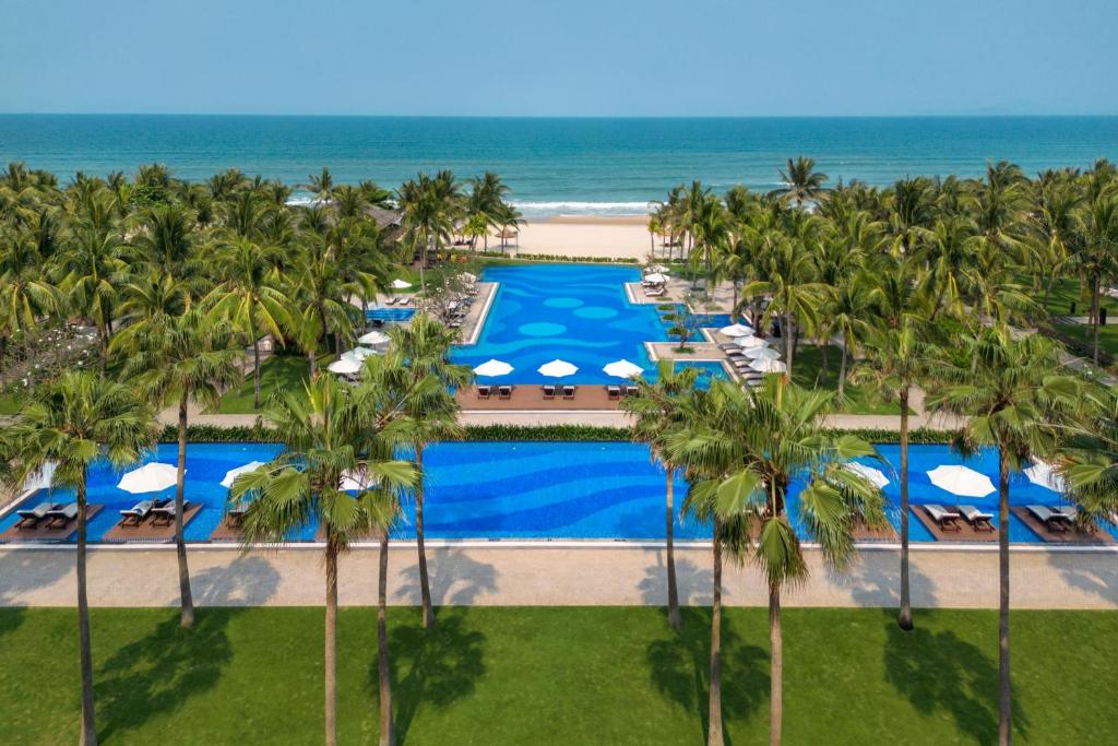 岘港Danang Marriott Resort & Spa的享有带游泳池和海洋的度假村的空中景致