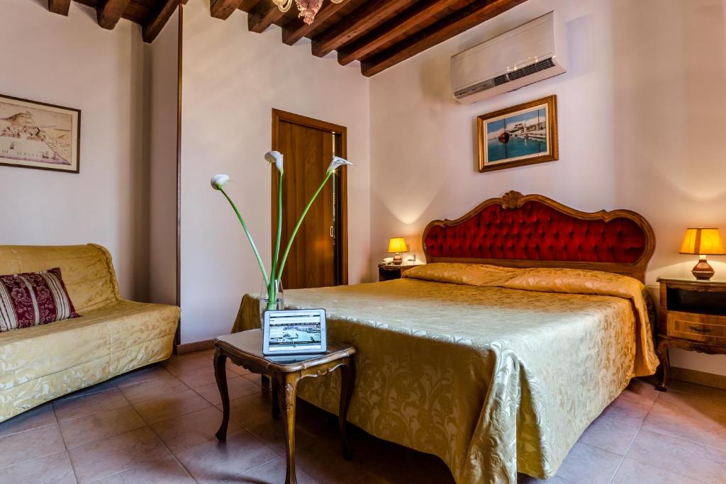 威尼斯爱丽儿希尔瓦酒店的一间卧室配有一张床和一张沙发