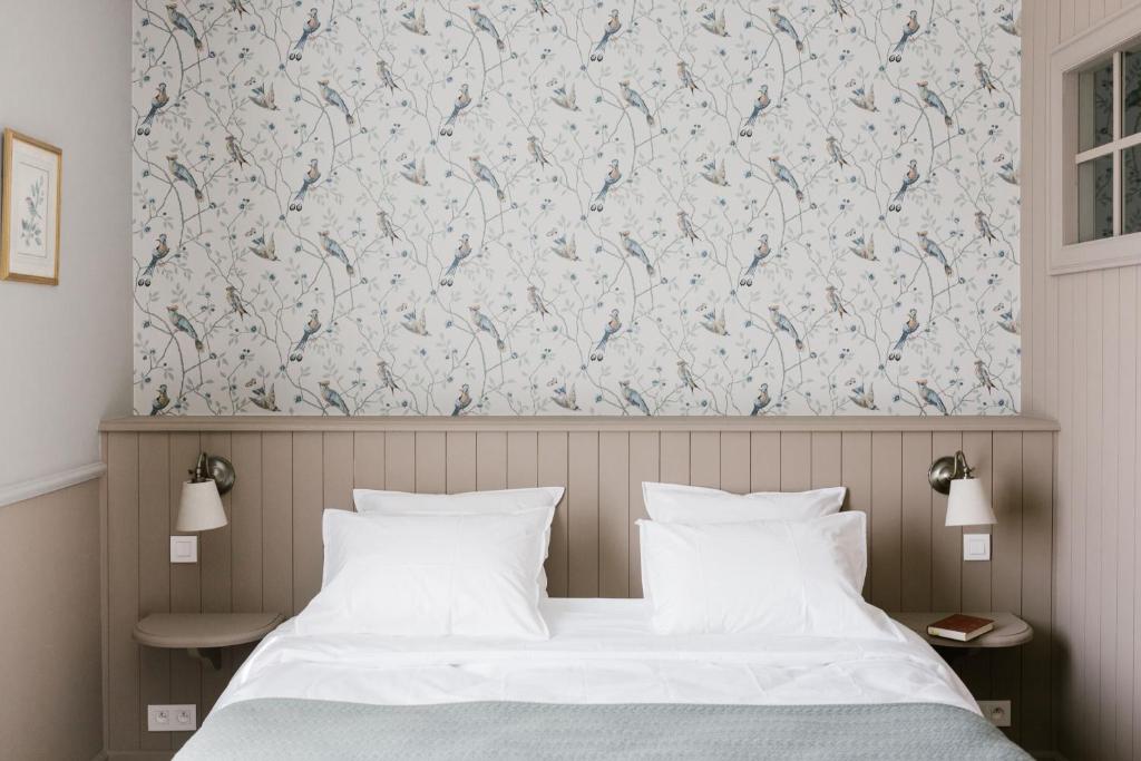 SillyLa Maison d’Hôtes的一间卧室配有一张带花卉壁纸的床