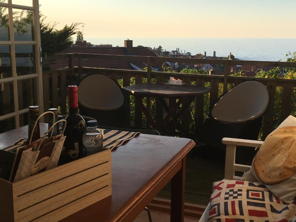 古兹耶姆SPECTACULAR PANORAMIC VIEWS OF GUDHJEM的阳台上的桌子和一瓶葡萄酒